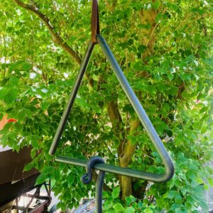 Handcrafted blacksmith-made dinner bell hanging outdoors, showcasing rustic charm and durable craftsmanship.
