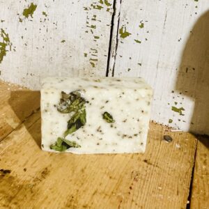 A bar of spearmint patchouli tranquility soap with goat milk and tallow, displayed against a serene, natural background.