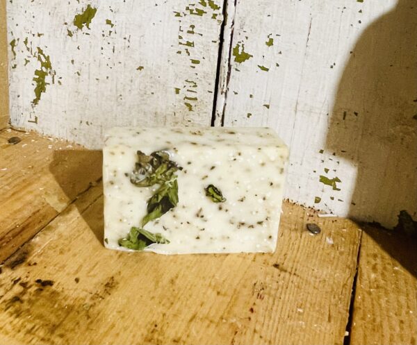 A bar of spearmint patchouli tranquility soap with goat milk and tallow, displayed against a serene, natural background.