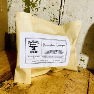 A goat milk shampoo bar made with tallow, displayed against a rustic wooden background.