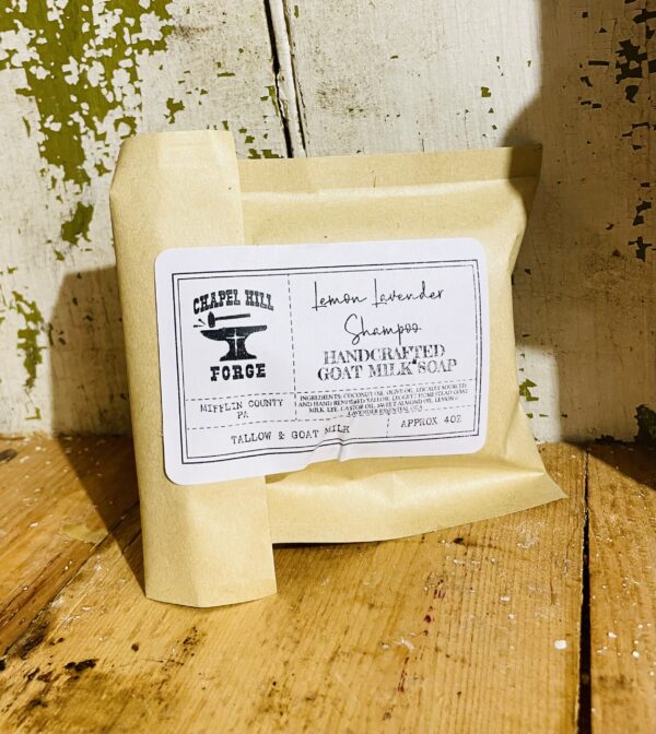 A bar of hair growth shampoo with goat milk, tallow, and lemon and lavender essential oils, displayed against a rustic background.