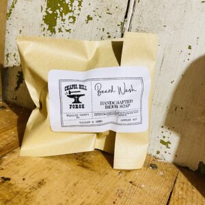 A bar of beard soap made with locally crafted beer and tallow, displayed against a rustic backdrop.