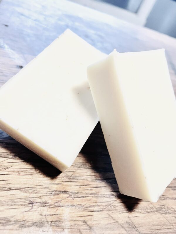 Tallow lotion bar made with locally sourced tallow, beeswax, and coconut oil on a wooden butcher block.